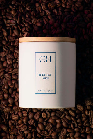 Coffee scented soy wax candle on top of fresh coffee beans