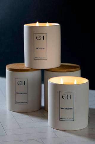 multiple candles lit in a dim room stacked on other candles